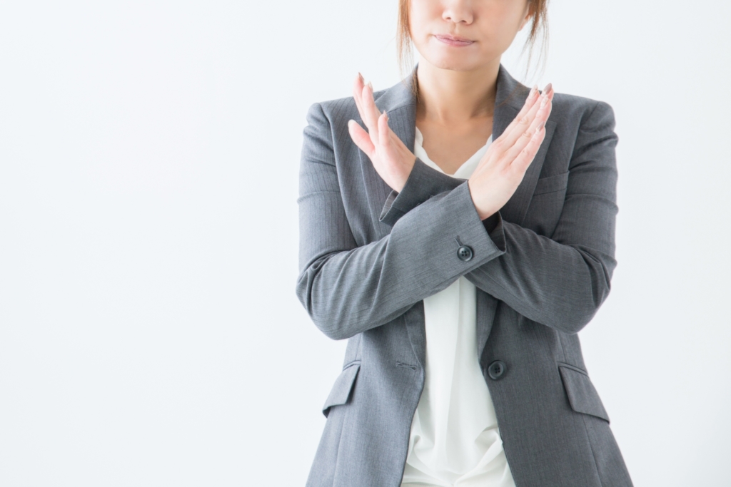 手でバツを表現している女性